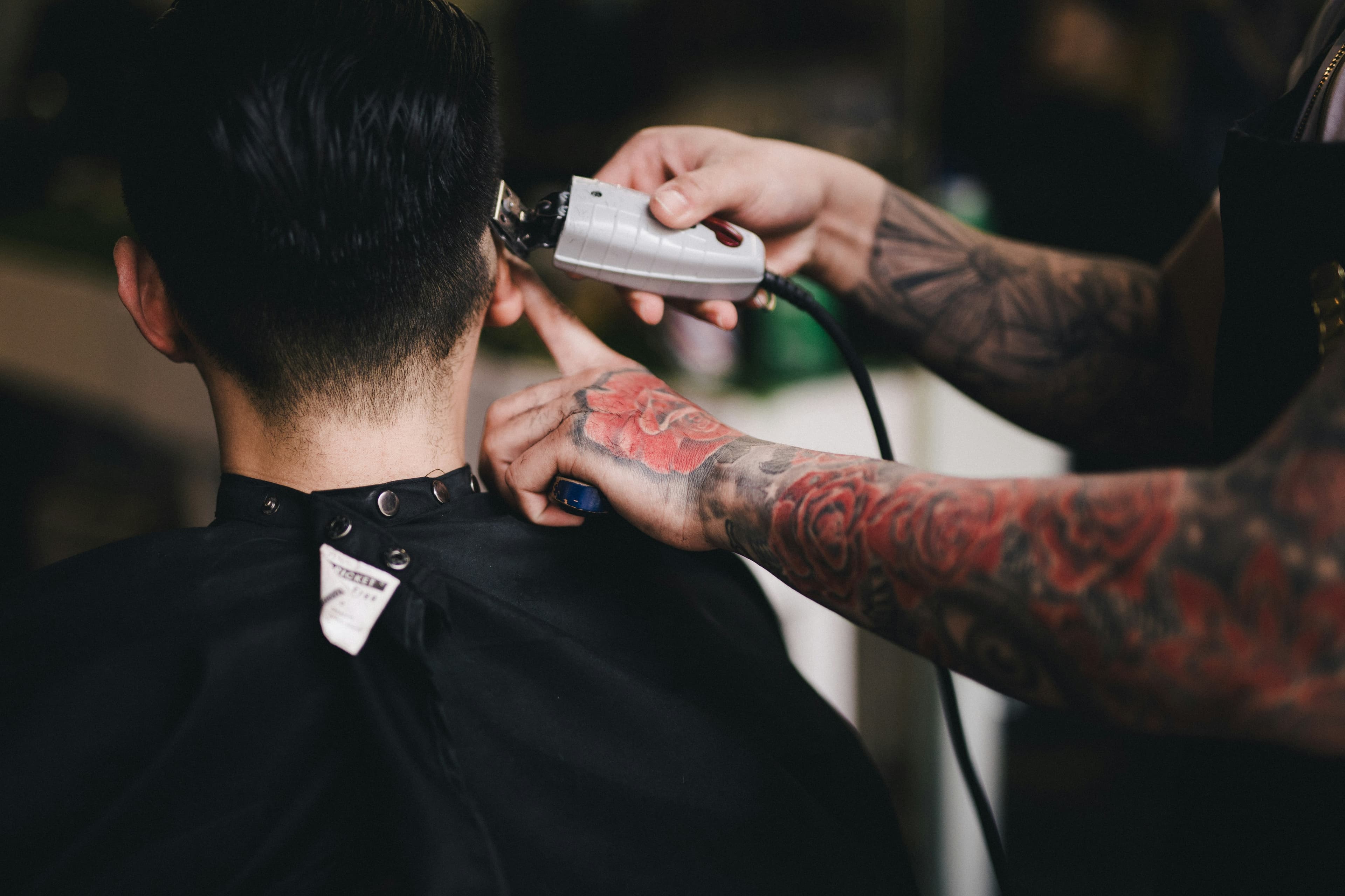 A barber trimming a client's hair with clippers