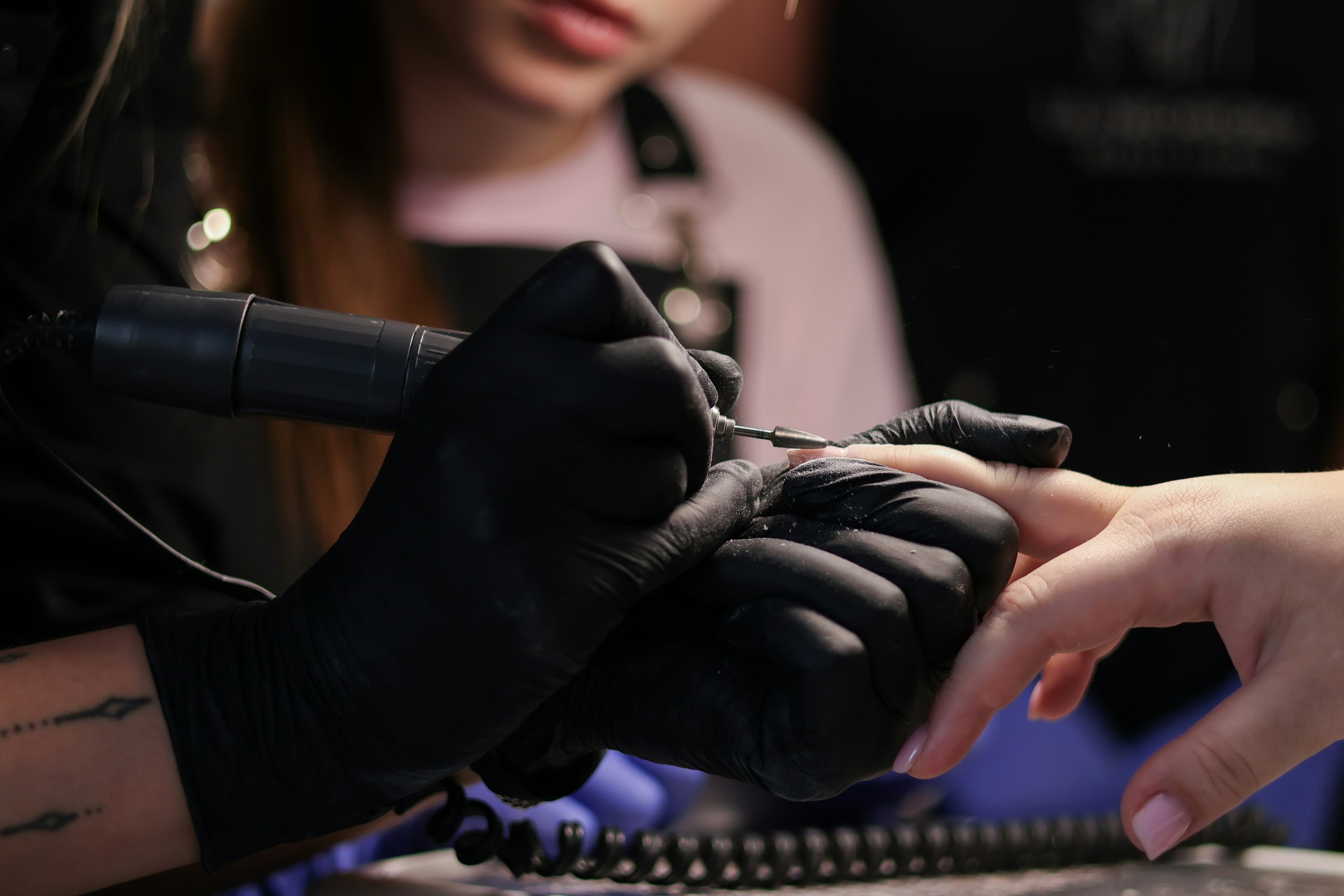 A solo nail technician working with one client